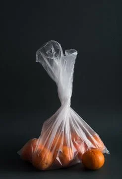 Oranges in plastic bag on a black background Stock Photos