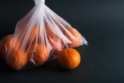 Oranges in plastic bag on a black background Stock Photos