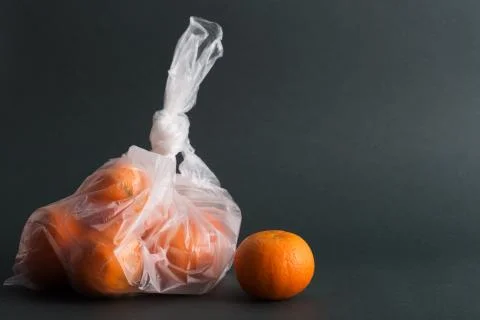 Oranges in plastic bag on a black background Stock Photos