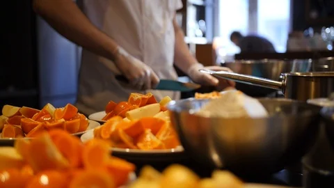 Oranges in plates lying on the table. Men's hands in gloves cut orange with a Video stock 123151455