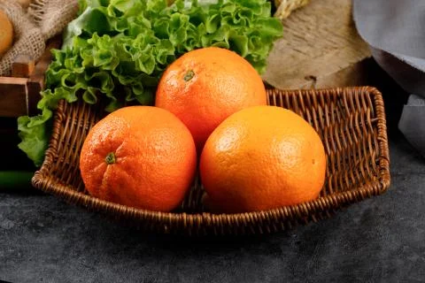 Oranges in a rustic platter with a lettuce around. Stock Photos