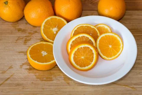 Oranges on a table and on a white plate Stock Photos