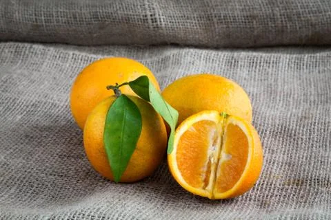 Oranges on table background and woven sack Stock Photos