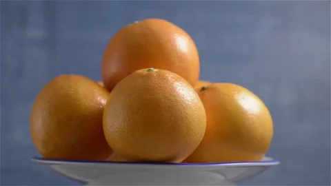 Oranges turning on a blue background Video stock 71714452