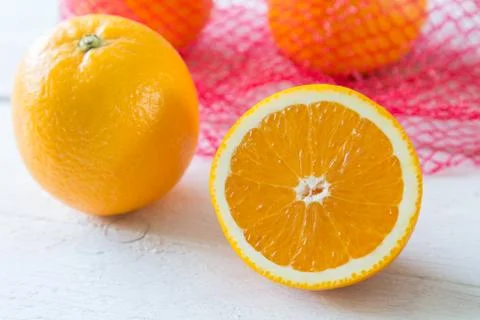 Oranges on a wooden table in the network Stock Photos
