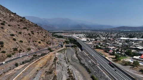 Orbit aerial shot over highway bridge crossing dry Aconcagua river bed at the Stock Footage 336267752