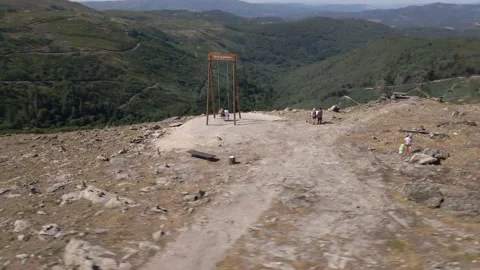 Orbit drone shot of 2 people riding in a wooden swing Stock Footage 170459805