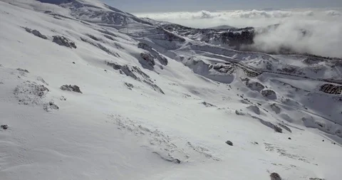Orbit drone shot of ski resort base station and parking lot above clouds Stock Footage 104655092