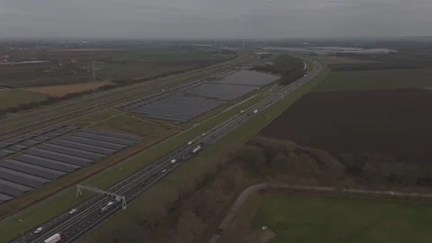 Orbit drone shot of solar farm near highway and railway infrastructure Stock Footage 330189918