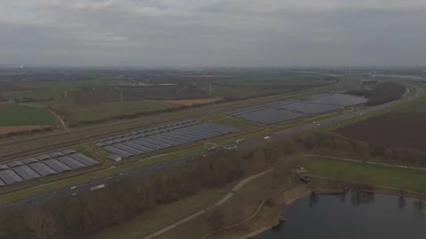 Orbit drone shot of solar farm with highway and railway infrastructure NL Stock Footage 330189975