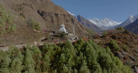 Orbit drone view of Namche Bazaar Nepal showing white chorten amidst green Stockbeeldmateriaal 337395875