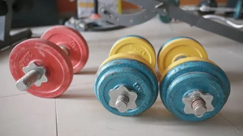 Orbit motion close up of the colored heavy adjustable dumbbell set lying on the Stock Footage 271573516