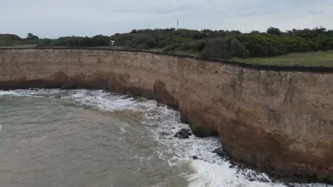 Orbit pan shot of big cliff front to ocean, close to road in South america Stock Footage 152957061