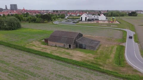 Orbit Shot Around Rustic Barn in Fields with Knokke in Distance | FlyLens 4K Stockbeeldmateriaal 309204908