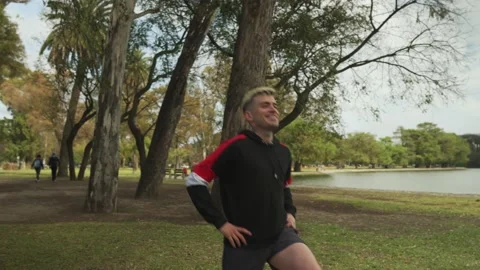 Orbit shot of a handsome man doing lunge exercises at park Stock Footage 140589341