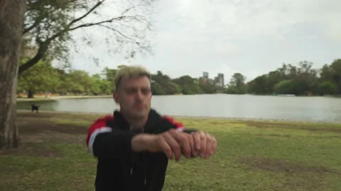 Orbit shot of a handsome man doing squats at park. Medium Stock-Footage 140590055