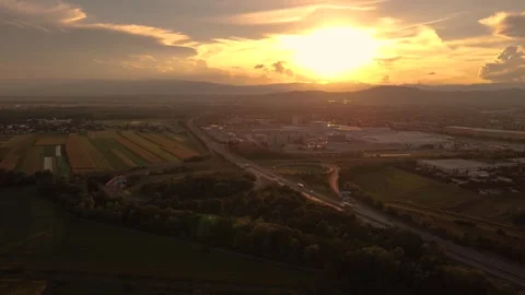 Orbit at sunset with a highway interchange and automobile plant 스톡 동영상 344742148