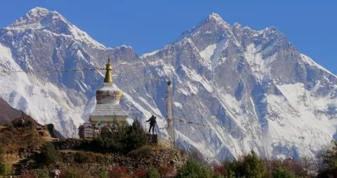 Orbit view of Buddhist stupa near Namche Bazaar Nepal showing trekker standing Stockbeeldmateriaal 337395613