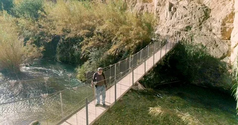 Orbital flight of old man's drone with gray beard looking at river Stock Footage 124387945