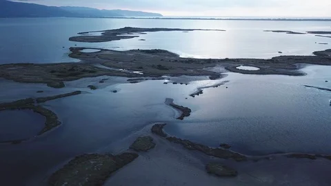 Orbital Flight over a lagoon lakes and islands, a cloudy sunset with reflections Stock Footage 97363544