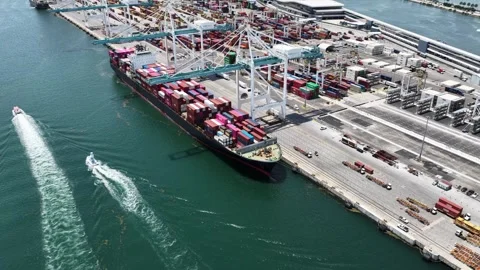 Orbiting aerial of container ship unloading at PortMiami terminal cranes Vídeo Stock 342646544