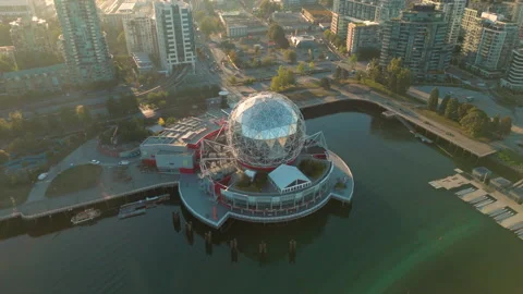 An orbiting aerial shot of a geodesic dome in False Creek, Vancouver Stock Footage 284765449