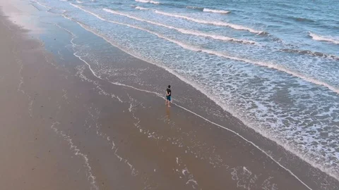 Orbiting around a young man on an empty beach in Cairns, Australia, 4K Stock Footage 106524527