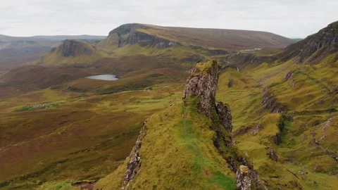 Orbiting cliff with a crow with the Quiraing background Stock Footage 246389319