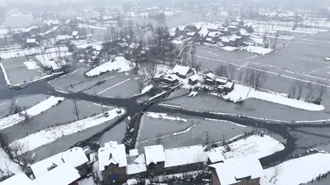 Orbiting drone footage showcasing Dal Lake’s winter beauty with snowfall gently Stock Footage 310223466