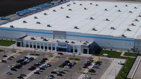 Orbiting drone shot above an Amazon fulfillment center revealing the smile logo Stock Footage 339025876