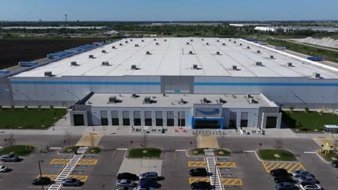 Orbiting drone shot ascending above the entrance and facade of a large Amazon Stock Footage 339025546