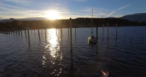 Orbiting drone shot of boat parked on lake during golden hour sunset Video stock 113322706