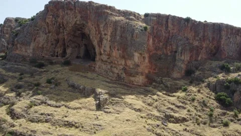 Orbiting drone shot of a large cliff face with ancient cave dwellings. Stock Footage 154752237