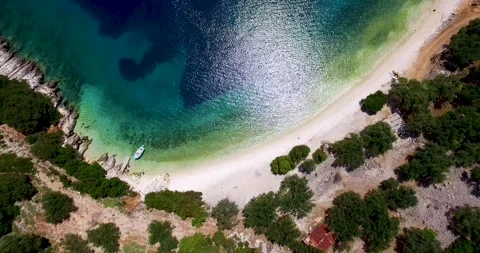 Orbiting drone shot of the stunning crystal clear waters and white pebbles Stock Footage 269030426