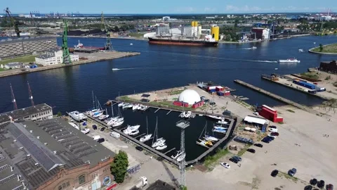 Orbiting drone video of a an old shipyard in a coastal city Stock Footage 246141479