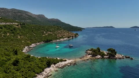 Orbiting drone view of a hidden beach and turquoise coastal lagoon Stock-Footage 345118632