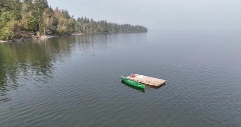 Orbiting flight around a lonely canoe on quiet waters Stock Footage 221116108