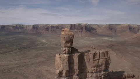 Orbiting high rock pillar with huge sandstone cliffs and desert beyond Stock Footage 124870345