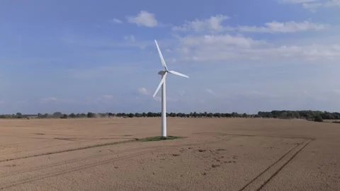 Orbiting a lwind turbines in fields on a sunny sommer day Stockbeeldmateriaal 325351238