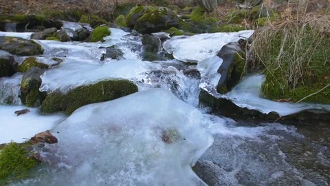 Orbiting shot on slider of high speed icy waterfall in alaska Stock Footage 85102398