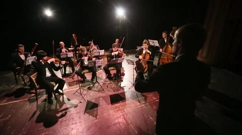 Orchestra with conductor on stage play Stock Footage 45174584