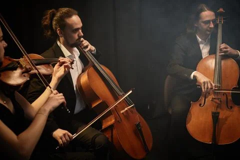 Orchestra Musicians Playing String Instruments on Black Background Stock Photos