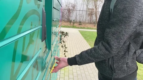Order online with Alegro. Guy picks up an order from a parcel machine. Stockbeeldmateriaal 237919183