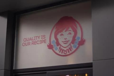 Order pick up window with text Quality is our recipe, sticker logo of Wendy's Stock Photos
