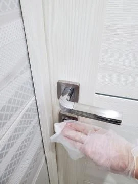 In order to prevent the spread of the virus and pandemic, wipe public door Stock Photos