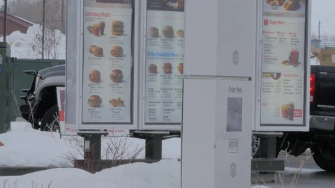 Ordering fast food at drive up in light snow storm. Video stock 71693514