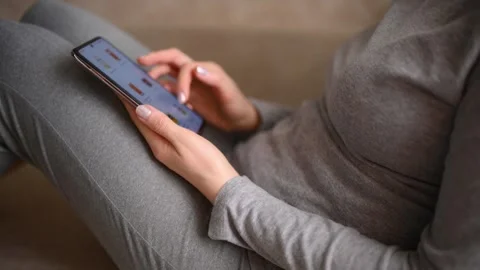 Ordering food using smartphone at home. Woman choosing drinks in online store Stock Footage 346917606