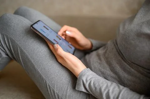 Ordering food using smartphone at home. Woman choosing drinks in online store Stock Photos