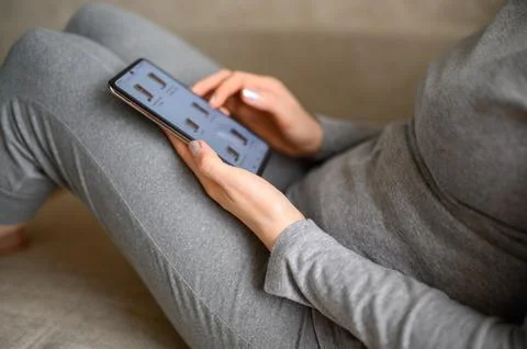 Ordering food using smartphone at home. Woman choosing drinks in online store Stock Photos