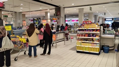 Orderly Queue at Hypermarket Payment Counter with Full Carts Stock Footage 321438799